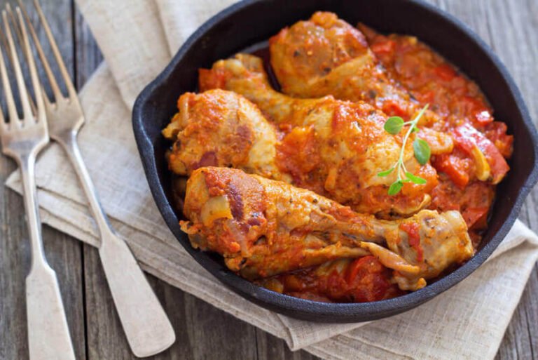 Traditional Italian chicken alla cacciatora with tomatoes, herbs, and vegetables served in a rustic dish