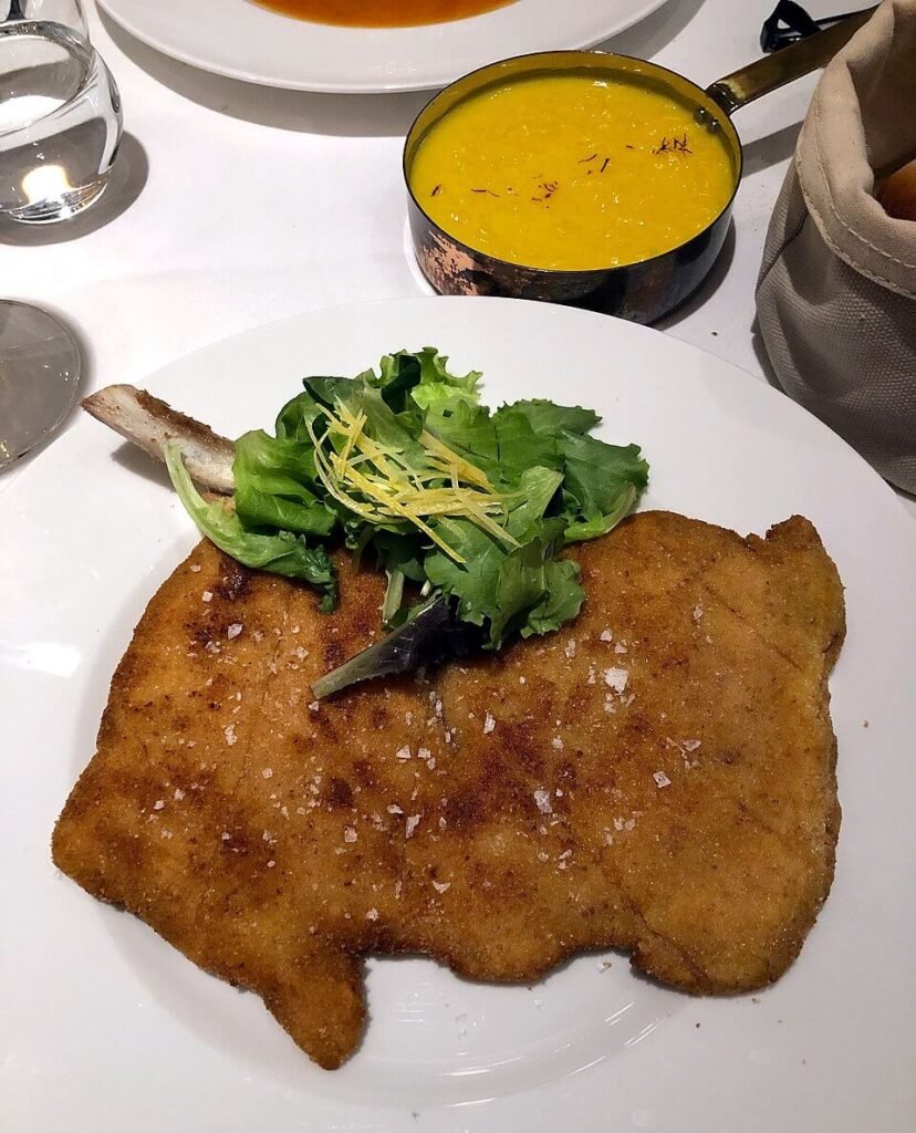Traditional Milanese veal cutlet served with lemon and side dish