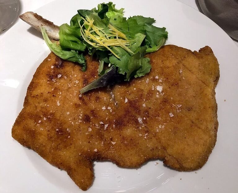 Traditional Milanese veal cutlet served with lemon and side dish