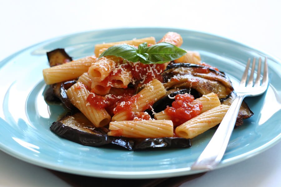 Pasta alla Norma: Sicilian pasta with eggplant, tomato sauce, ricotta salata, and basil.