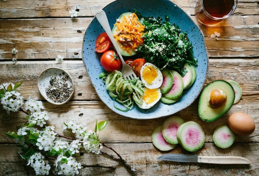 Piatto vegetariano su piatto di ceramica con frutta e verdura addobbi floreale