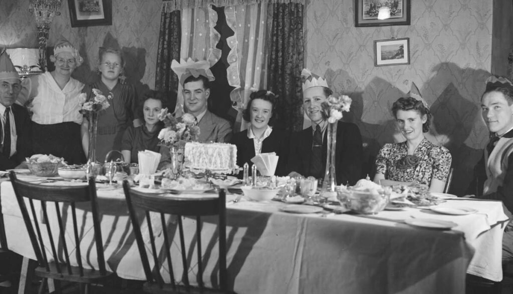 Italian family sitting around a festive table full of food, all smiling together