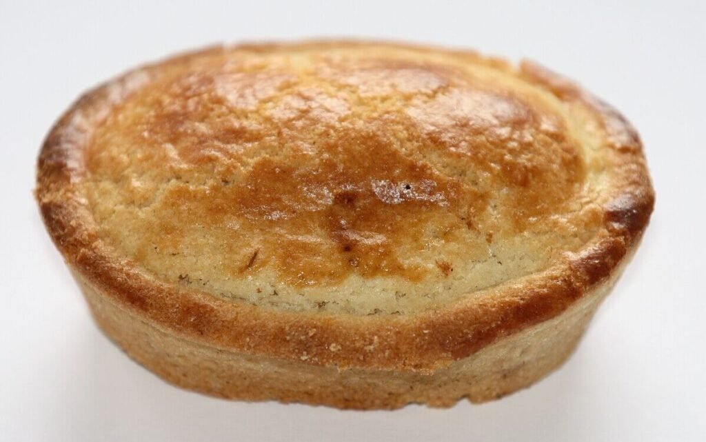 Warm Pasticciotto Leccese with golden crust and lemon-vanilla custard filling. Traditional Puglian Custard-Filled Pastry