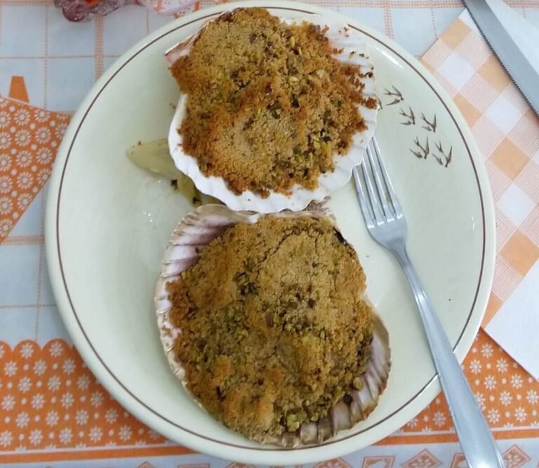 Baked scallops with pistachios, a refined seafood dish from Friuli Venezia Giulia, Italy. Gratinated Scallops
