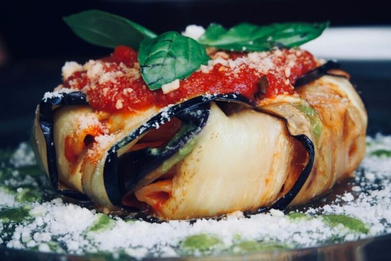Traditional Sicilian timballo di maccheroni, baked pasta pie with golden crust and layered filling of ragù, peas, mozzarella and boiled eggs