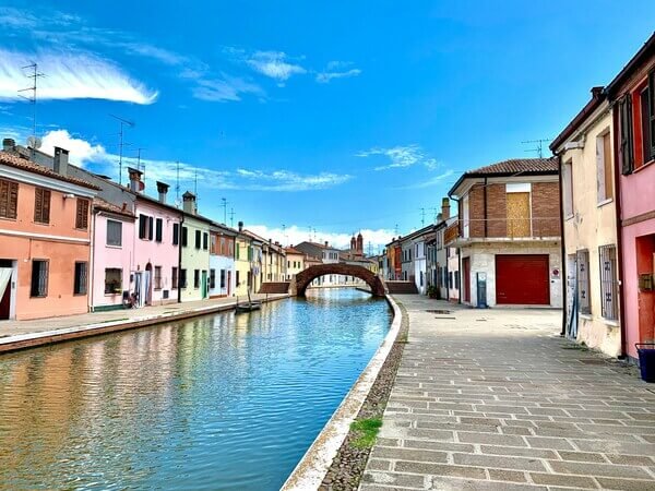 Comacchio Emilia-Romagna pastel townhouses reflecting in canal at sunrise
