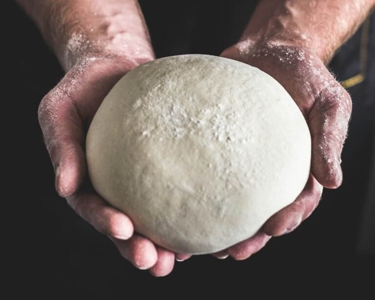 Authentic Neapolitan pizza dough preparation with Italian flour and hands kneading on a wooden surface