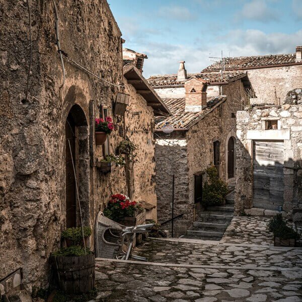 Scenic view of an ancient village in Abruzzo, Italy, surrounded by hills and historic stone houses.