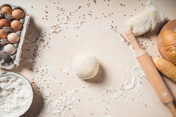 Lasagna pasta ingredients – flour, semolina, eggs, and salt on wooden board